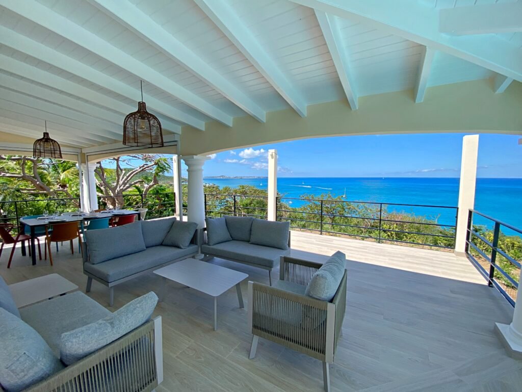 Terrasse couverte avec salon extérieur et vue mer