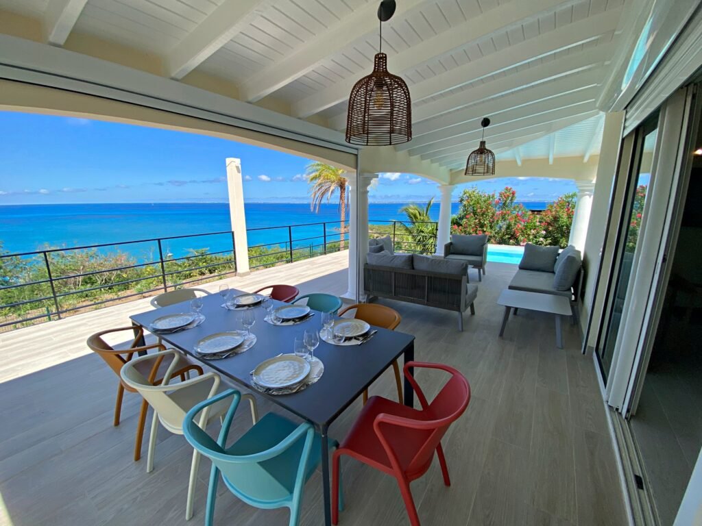 Terrasse couverte avec salon extérieur et vue mer