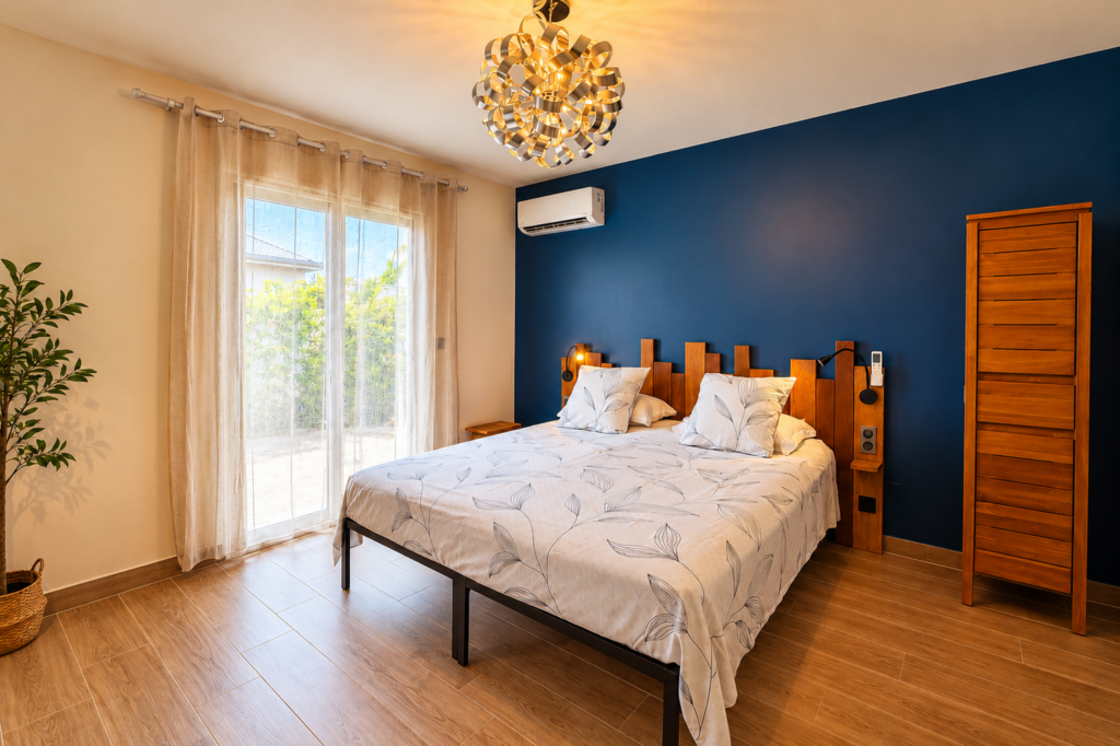 chambre avec mur bleu de la villa Sunset avec lit king size à Saint-Martin